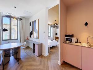 a kitchen and living room with a table and a bed at Maison 65 in Pierrelatte