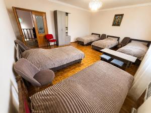 a room with three beds and a table and chairs at Adams Rest House in Yeghegnadzor