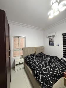 a bedroom with a bed with a black and white comforter at The Luxe Haven in Lekki Phase 1