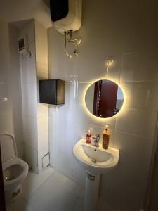 a bathroom with a sink and a toilet and a mirror at The Luxe Haven in Lekki Phase 1
