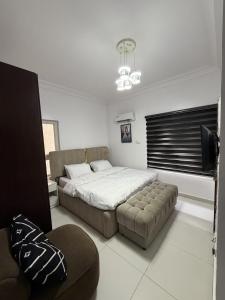a bedroom with a bed and a couch in it at The Luxe Haven in Lekki Phase 1