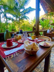 a wooden table with plates of food on it at Pousada Recanto Afetivo in Trindade