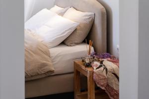 a couch with white pillows and a wooden table at Apanema Mindfulness, Relaxing Adults Only Resort, Fast WiFi, Pool, Sauna, Massage in Asprogerakata