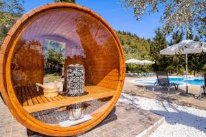 a wooden barrel sitting next to a swimming pool at Apanema Mindfulness, Relaxing Adults Only Resort, Fast WiFi, Pool, Sauna, Massage in Asprogerakata