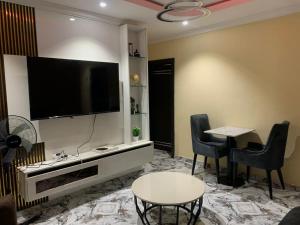 a living room with a tv and a table and chairs at E&G homed in Lagos