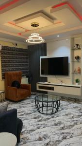 a living room with a television and a couch and a table at E&G homed in Lagos