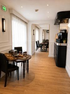 a room with a table and chairs and a kitchen at Hôtel Gallia Cannes in Cannes