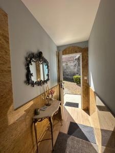 a hallway with a table and a mirror on the wall at Casa da Xueza in Vales