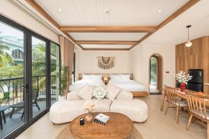 a hotel room with a bed and a table at Maison Thu in Phú Quốc