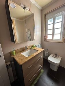 a bathroom with a sink and a toilet and a mirror at Casa da Xueza in Vales +11 photos