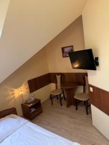 ein Hotelzimmer mit Bett, Fernseher und Tisch in der Unterkunft Hotel Viwaldi in Baruchowo