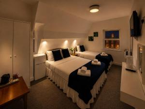 a hotel room with two beds and a television at Alexandra Hotel Blackpool in Blackpool