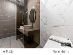 a bathroom with a toilet and a sink and a mirror at 호텔뷰 in Tomin-dong +5 photos