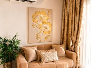 a couch in a living room with a flower painting on the wall at GOLDENSPACE by Evagelias Homes Volos in Volos