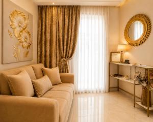 a living room with a couch and a large window at GOLDENSPACE by Evagelias Homes Volos in Volos