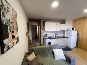 a living room with a couch and a kitchen at Casa Wood in Guarda +5 photos
