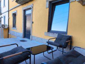 a patio with two chairs and a table and a window at Casa Stone in Guarda