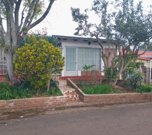 a house with trees and flowers in front of it at Hospedaje Nely in San Vicente