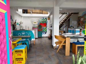 a room with tables and chairs and a kitchen at hostal combi in Salento