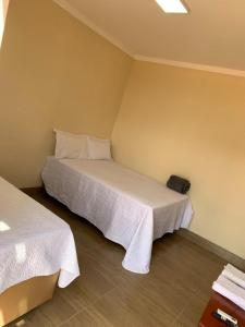 a bedroom with two beds with white sheets at Pousada Jalapão Sunset in Mateiros