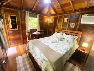a bedroom with a bed in a room with wooden walls at Pousada Recanto Afetivo in Trindade