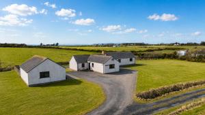 an aerial view of two white houses in a field at Wildeston in Thurso