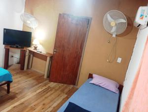 a room with a door and a bed and a fan at Alojamientos Lilu in Colón