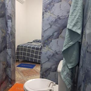 a bathroom with a toilet and a blue marble wall at Bem no Centro in Juazeiro do Norte