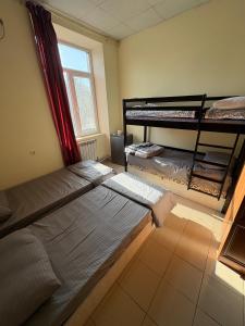 ein Schlafzimmer mit zwei Etagenbetten und einem Fenster in der Unterkunft Ruma Hotel in Yerevan