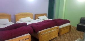 two beds in a room with purple blankets on them at Moon Palace by MZ Hotels Pakistan KPK in Mingāora