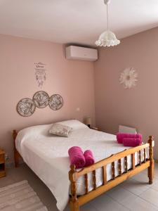 a bedroom with a bed with pink pillows on it at Le Grand Gîte in Pellegrue +24 photos