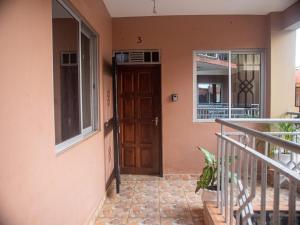 a house with a wooden door and a balcony at Queen Tori in Malindi
