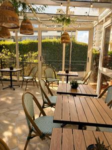an outdoor patio with wooden tables and chairs at Hôtel Gallia Cannes in Cannes
