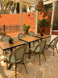 a patio with two wooden tables and chairs at Hôtel Gallia Cannes in Cannes +53 photos