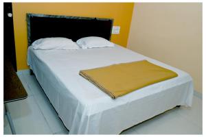 a large white bed with a blanket on it at MTDC Shivtej in Kolhapur