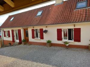 a house with red doors and a red roof at Chez Annick in Escoeuilles
