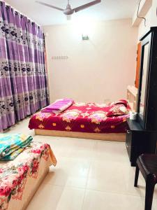 a bedroom with two beds in a room with purple curtains at Ast Guest House in Dhaka
