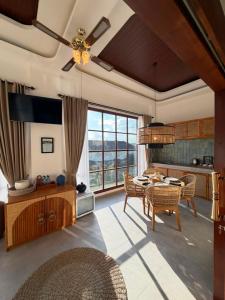 a living room with a dining table and a kitchen at Casa Maddu in Tegalalang