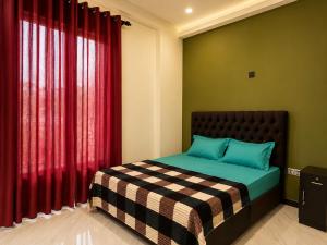 a bedroom with a bed and a red curtain at Skylurk Transit in Negombo