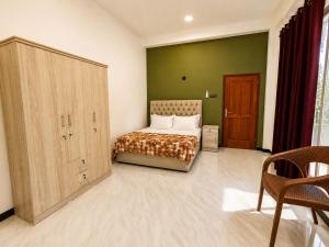 a bedroom with a bed and a green wall at Skylurk Transit in Negombo