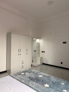a white room with a bed and a closet at Skylurk Transit in Negombo
