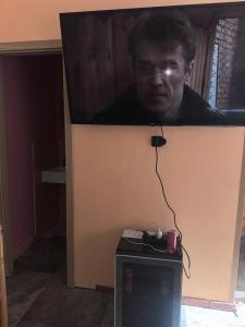 a picture of a man on top of a tv at Queens Safehouse in Brozany