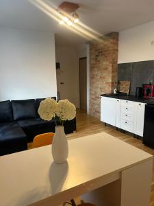 a living room with a vase with flowers on a table at Apartamenty Leszczynowa in Łomża
