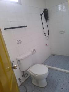 a bathroom with a toilet and a phone on the wall at Happy 2 Pratunam Hotel in Bangkok +7 photos
