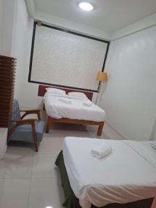 a room with two beds and a large screen at Happy 2 Pratunam Hotel in Bangkok