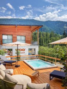 a pool on a deck with chairs and umbrellas at WOO® Loft Resort in Fiesch
