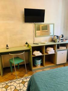 a room with a desk with a television and a chair at Marieta Rooms in Sarzana