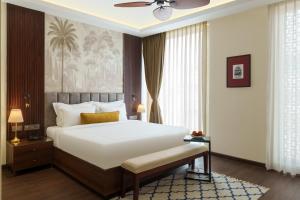 a bedroom with a large bed and a ceiling fan at Oraka by My Downtown Aura Hotel in Udaipur