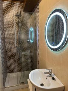 a bathroom with a sink and a shower with a mirror at Casa dos Acevedo in Verín