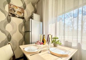 a kitchen with a table with two plates and a refrigerator at Naykova district Apartments in Kharkiv